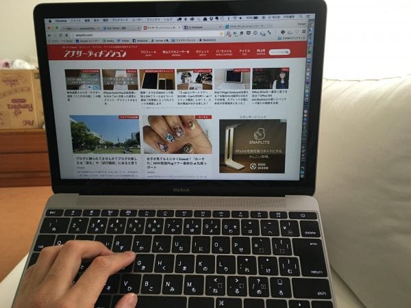 寝転がって膝を立ててMacBookをおいた状態