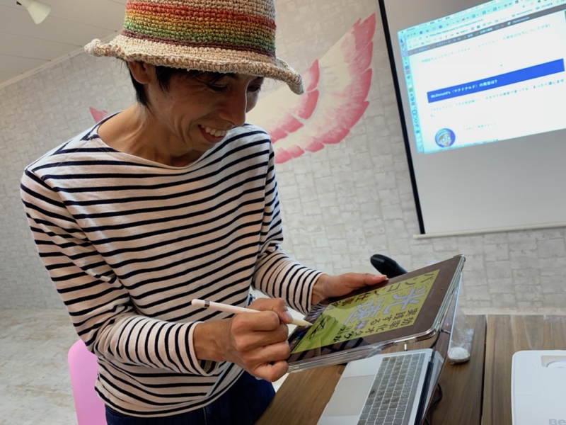 iPadにサインするヨスさん