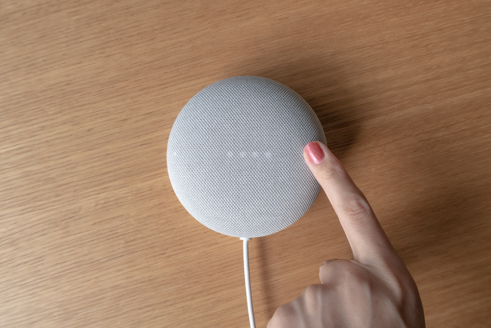 Google Nest Miniを指で押している写真